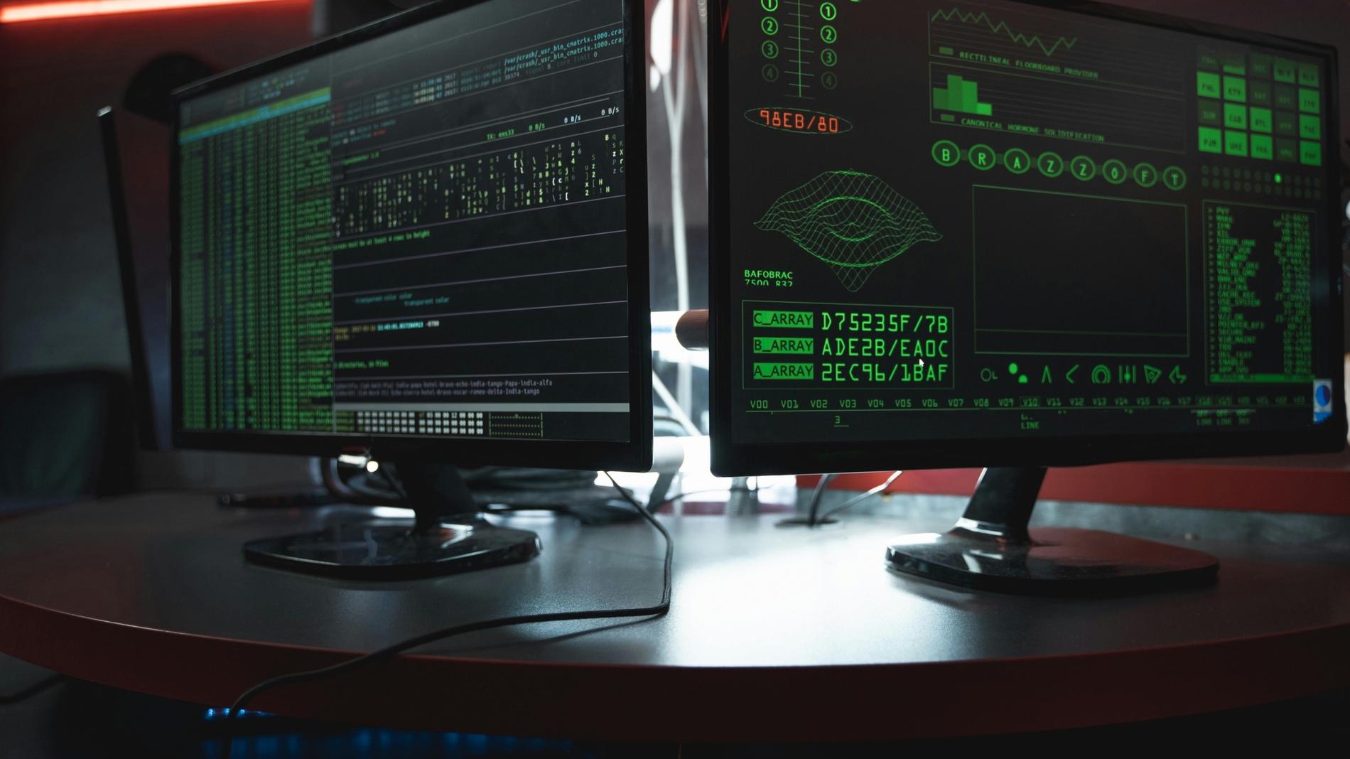 A pair of computer monitors displaying various data